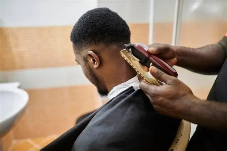 Professional barber giving stylish haircut